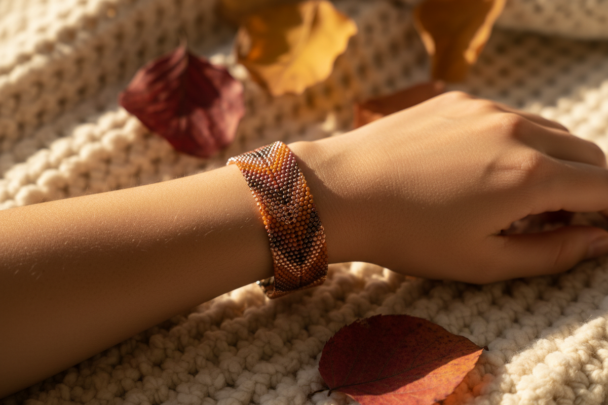 Ember Dusk Bracelet worn on wrist on cream knit blanket with autumn leaves